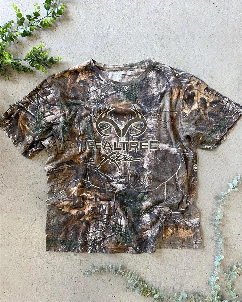 Vintage camo clothing collection featuring RealTree t-shirts, military jackets, and rugged outdoor workwear from the 90s and early 2000s.