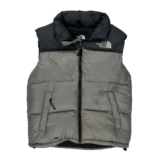 Gray puffer vest with black collar and The North Face logo on a white background